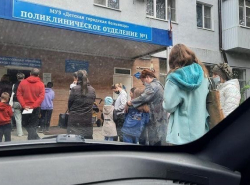 Мамочки с детьми стоят на улице в очереди в поликлинику